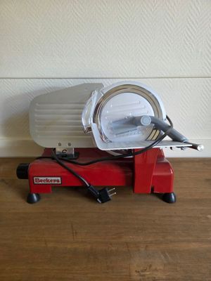 une machine rouge posée sur un plancher en bois