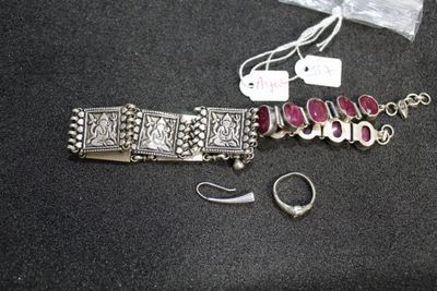 a silver bracelet and a pair of earrings sitting on a table