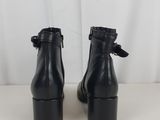 a pair of black leather ankle boots with buckles on each side