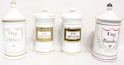 trois boîtes blanches et dorées posées sur une surface blanche