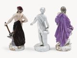 three figurines of a man and a woman holding a shovel