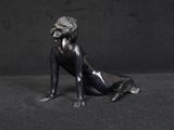 statue of a woman sitting on the ground with her legs crossed