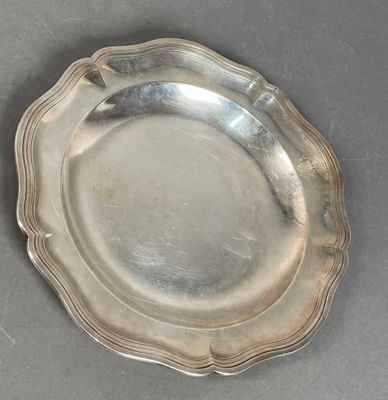 silver plate with scalloped edge on grey surface