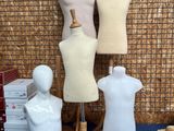 trois mannequins assis sur une table bleue