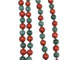 a close up of a long necklace with red and green beads