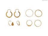 un gros plan sur un ensemble de boucles d'oreilles dorées sur fond blanc