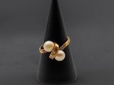 une bague en or sertie de perles et de diamants, montée sur un cône noir
