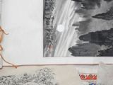 a cat that is sitting on the floor in front of a picture