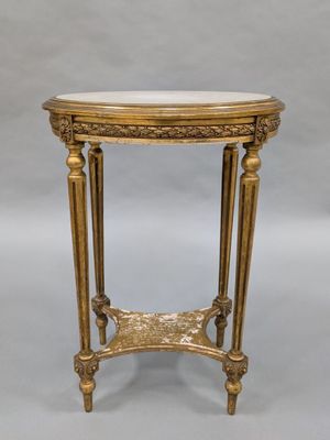 une table dorée avec un plateau en marbre sur fond gris