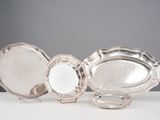 trois assiettes plaquées argent posées sur une table blanche, sur fond gris