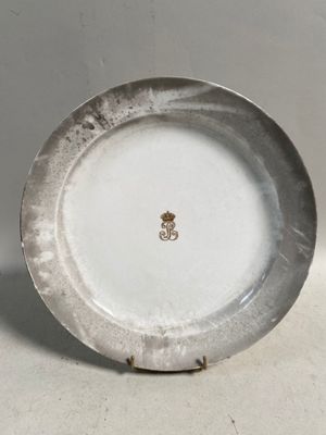 une assiette blanche ornée d'un emblème doré