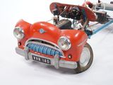 a red toy car with a snowboard attached to the back of it
