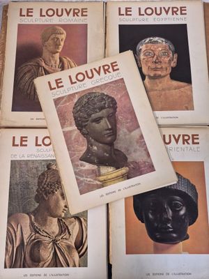 several books with pictures of ancient statues on them sitting on a table
