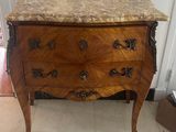 a marble top chest of drawers in the corner of a room