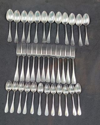 a lot of spoons and forks arranged together on a table