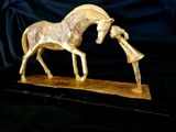 a statue of a horse that is standing on a wooden base
