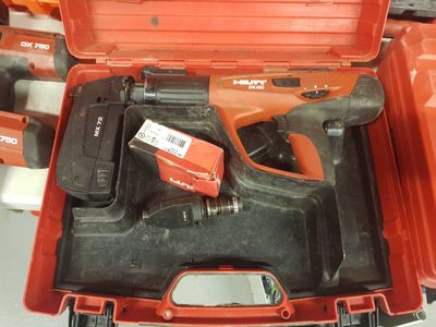 une boîte à outils rouge contenant un marteau et d'autres outils