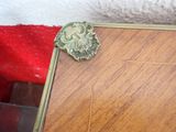 a small mirror on the floor next to a red blanket