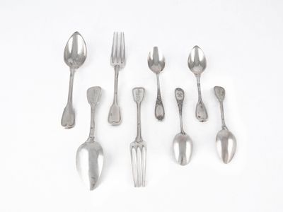 un grand nombre de cuillères et de fourchettes en argent sur une surface blanche