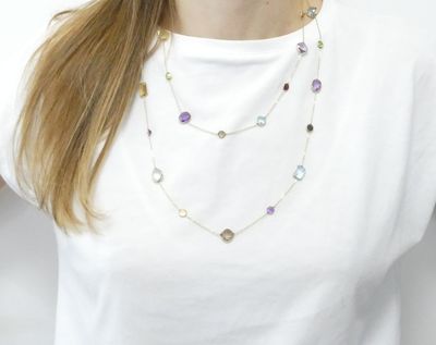 the woman is wearing a white t - shirt and a multi - colored necklace