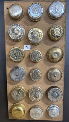 Plusieurs types de boutons sont présentés sur une planche en bois