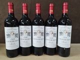 six bouteilles de vin sont alignées sur une table