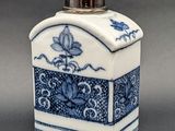 une petite bouteille bleue et blanche ornée d'un motif floral