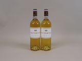 two bottles of white wine sitting next to each other on a table