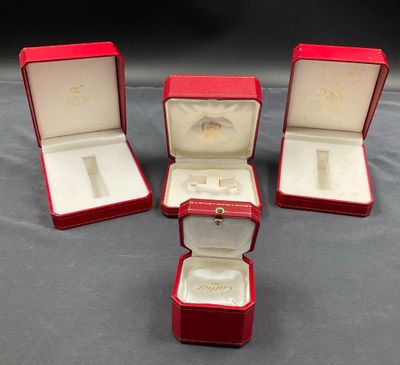 trois boîtes rouges contenant chacune une bague, posées sur une table