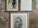 three framed drawings of a man and a woman on a wall