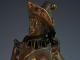 bronze statue of a woman with a hat and a bird on her shoulder