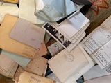 a pile of old papers on the floor next to a cat