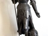 une statue représentant une femme tenant une lance et un bouclier