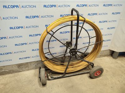 a cart with a hose on it in front of a wall