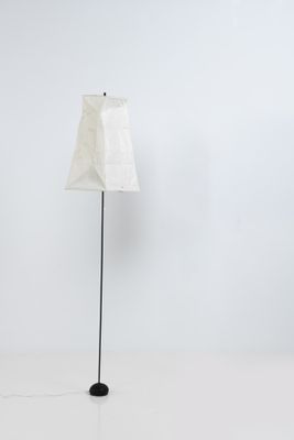 lampe sur pied en forme d'abat-jour, avec un pied en métal noir et un abat-jour en tissu blanc