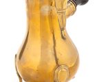 une cafetière ancienne en laiton posée sur un support, sur fond blanc