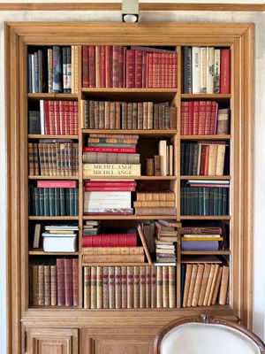 a chair in front of a bookshelf full of books