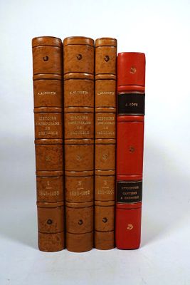 four books that are lined up on a white surface