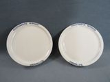 deux assiettes blanches avec des inscriptions bleues, posées sur une table