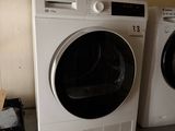 deux lave-linge et un sèche-linge posés sur un meuble