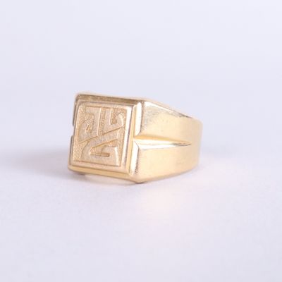 an image of a gold signet ring on a white surface