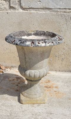 a bird that is standing next to a stone planter