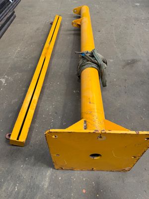 a yellow pole sitting on the ground next to a pile of metal