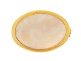 a close up of a gold and mother of pearl broochle