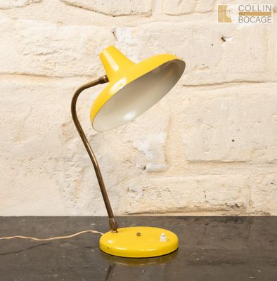 une image représentant une lampe de table jaune posée sur une table noire