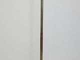 a brass floor lamp with a white shade on top