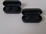 a pair of black ear buds sitting on top of a table
