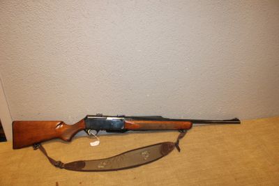 le fusil est posé sur la table, à côté du pistolet