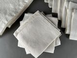 several white napkins are stacked on top of each other on a table