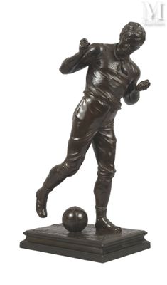 statue en bronze représentant un homme en train de frapper un ballon de football, posée sur un socle